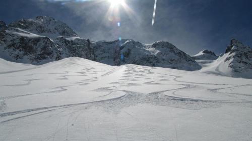 een met sneeuw bedekte berg met de zon in de lucht bij Hôtel Val d'Este in Saint-Gervais-les-Bains