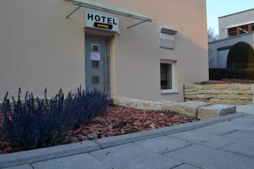 un panneau d'hôtel sur le côté d'un bâtiment dans l'établissement Hotel Myrsini, à Kirchentellinsfurt