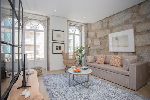 a living room with a couch and a table at Liiiving in Porto - Luxury Beachfront Apartments in Porto