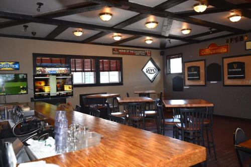 un bar con mesas de madera y sillas en un restaurante en The Drake Inn, en Canmore