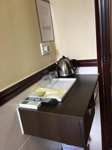 a table with a tea pot and a telephone on it at Hang Ho Hostel in Hong Kong