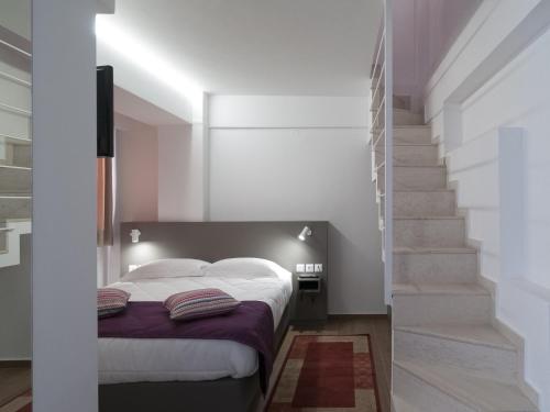 - une chambre avec un lit et un escalier dans l'établissement Olympos Suites Apartments, à Leptokaryá