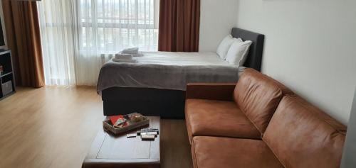 uma sala de estar com um sofá e uma cama em Студио Тони em Varna