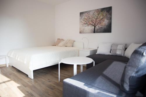 een witte slaapkamer met een bed en een bank bij Apartament Kameralny in Kazimierz Dolny