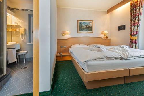 una camera d'albergo con letto e bagno di Albergo Contrin a Campitello