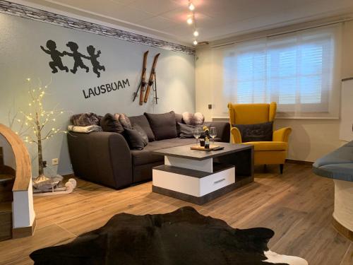 een woonkamer met een bank en een tafel bij Apartment Lausbuam in Mühlbach am Hochkönig