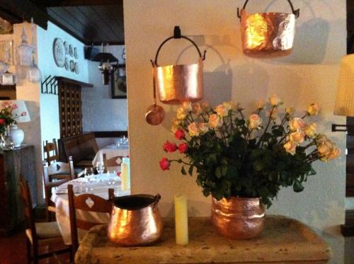 uma mesa com um vaso de flores em La Locanda Del Grop em Tavagnacco