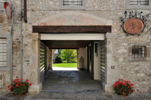 um arco num edifício de pedra com flores em La Locanda Del Grop em Tavagnacco