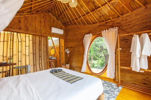 a bedroom with a bed and a window at Trang An Lamia Bungalow in Ninh Binh