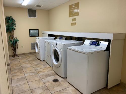 a laundry room with three washing machines and a counter at Candlewood Suites Jonesboro, an IHG Hotel in Jonesboro