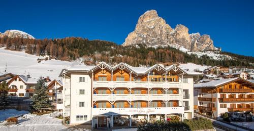 un grande hotel con una montagna sullo sfondo di Hotel Gran Fanes a Corvara in Badia