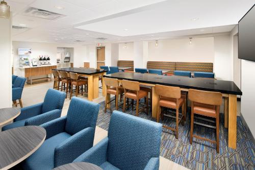 una sala conferenze con sedie blu e un lungo tavolo di Holiday Inn Express & Suites College Park - University Area, an IHG Hotel a College Park