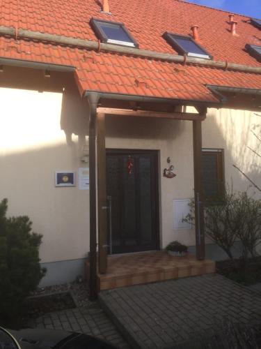 una puerta delantera de una casa con terraza de madera en Ferienwohnung Herbsleben, en Herbsleben