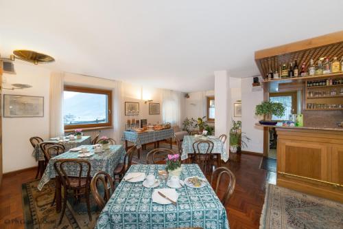 una sala da pranzo con tavoli e sedie e una cucina di Hotel Terme a Bormio