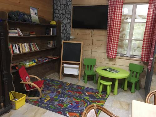 een woonkamer met een tafel en stoelen en een televisie bij Rute Hotel and Apartments in Kranjska Gora