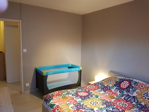 1 dormitorio con 1 cama y TV en la pared en Le Bellevue, en Colmar