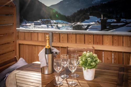 eine Flasche Wein auf einem Tisch mit Weingläsern in der Unterkunft Appartamento Lusso Panoramic - Andalo in Andalo