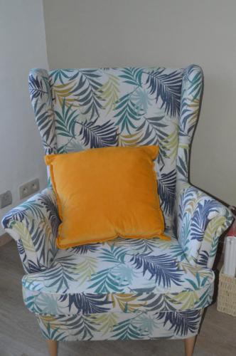 an orange pillow on a blue and white chair at Evelyns Corner Duplex in Ghent