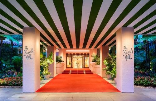 a red carpet leading to the front door of a building at The Beverly Hills Hotel - Dorchester Collection in Los Angeles