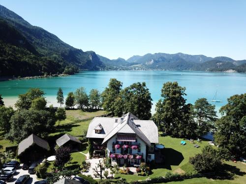 - une vue aérienne sur une maison à côté d'un lac dans l'établissement Landhaus Leitner am Wolfgangsee, à Sankt Gilgen