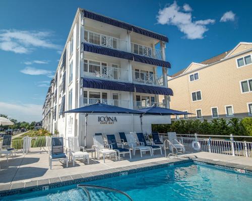 ein Hotel mit einem Pool mit Stühlen und Sonnenschirmen in der Unterkunft ICONA Cape May in Cape May