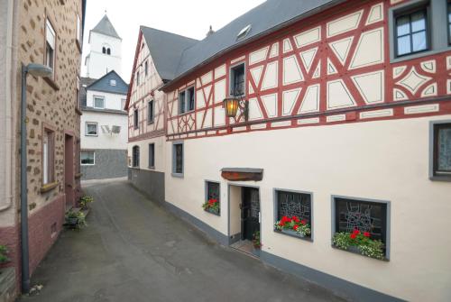 een steegje met bloemen in de ramen van gebouwen bij Alte Weinstube Burg Eltz in Treis-Karden