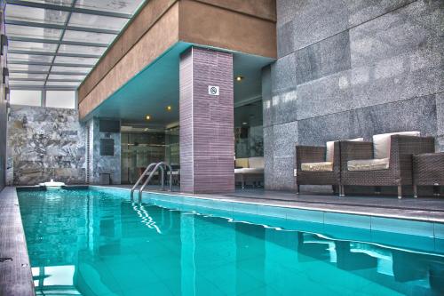 una piscina in un hotel con sedie e un edificio di Casa Inn Galerias Celaya a Celaya