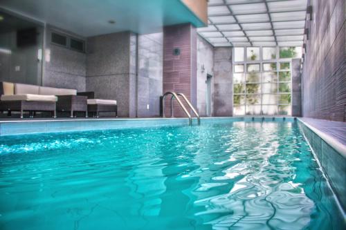 una piscina con acqua blu in un edificio di Casa Inn Galerias Celaya a Celaya