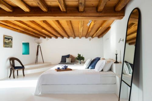 una camera con letto e soffitto in legno di The Vasilicos a Imerovigli