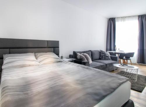 een slaapkamer met een groot bed en een bank bij Main Square Modern Apartments in Zagreb