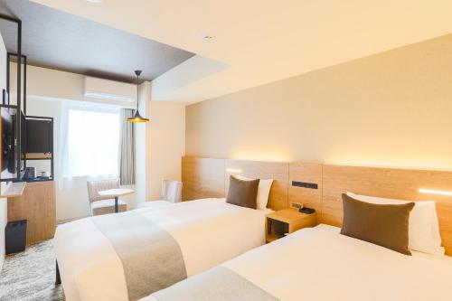 A bed or beds in a room at Hotel Wing International Sapporo Susukino