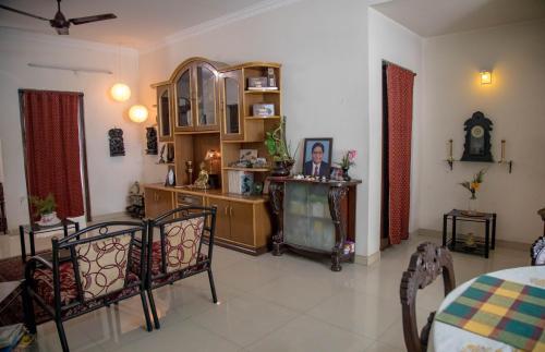 een woonkamer met een tafel en stoelen bij Homestay for Women in Coimbatore