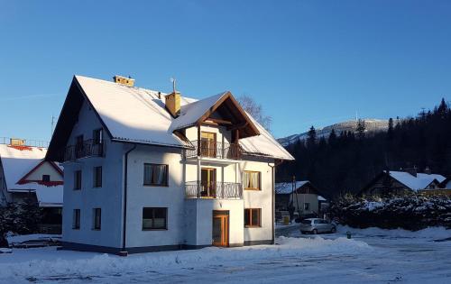 uma casa branca com neve no telhado em Hołdysówka przy Gondoli em Szczyrk