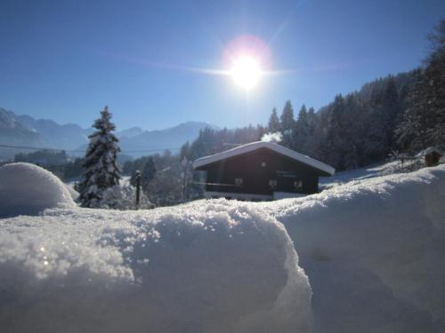 une pile de neige devant une cabine dans l'établissement Landhaus Eggensberger, à Fischen im Allgäu