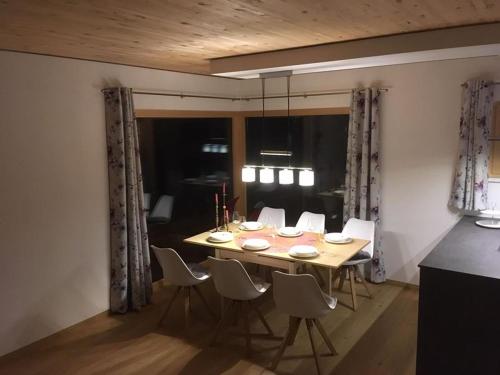 comedor con mesa de madera y sillas en Chalet Vacanza, en Brand