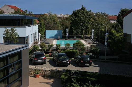 due auto parcheggiate in un parcheggio accanto alla piscina di Reghina Blue Hotel a Timişoara