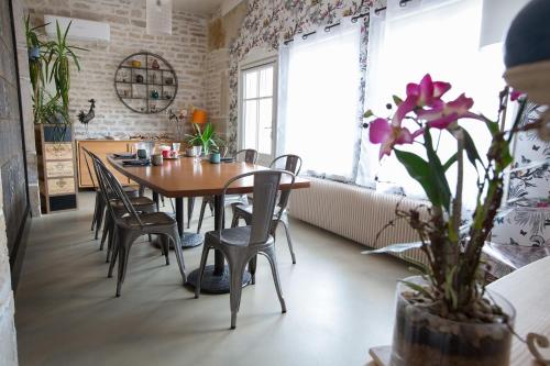 uma sala de jantar com uma mesa de madeira e cadeiras em Ma Maison em Beaune