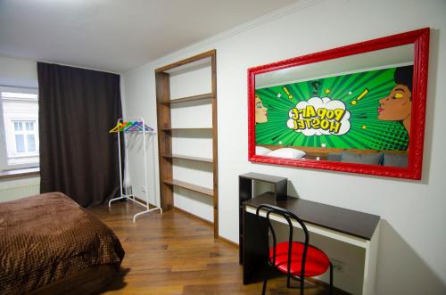 um quarto com uma cama e uma secretária com um jogo de vídeo na parede em Pop Art Hostel Rynok Sq em Lviv