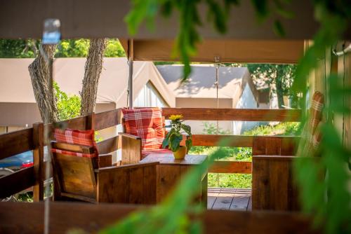 eine Veranda mit einer Bank und einem Tisch mit einer Pflanze in der Unterkunft Sunflower Camping in Novigrad Istria