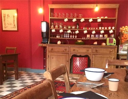 une salle à manger avec une table et un mur rouge dans l'établissement The Black Hole, à Winchester