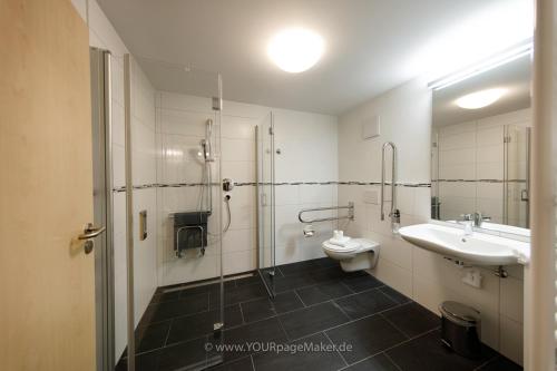 La salle de bains est pourvue d'une douche, de toilettes et d'un lavabo. dans l'établissement Hotel-Restaurant Römerhof, à Herrenberg