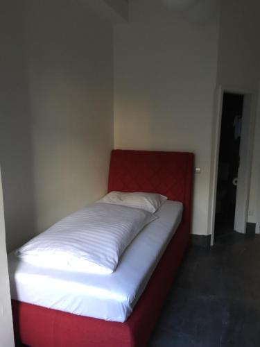 een bed in een kamer met een rood en wit matras bij Wasserturm Hotel Mannheim in Mannheim