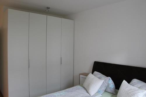 Schlafzimmer mit weißen Wänden und einem Bett mit weißen Kissen in der Unterkunft Ferienwohnung Dado in Eisenstadt