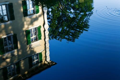 a reflection of a building in a body of water at Schloss Burgellern in Scheßlitz