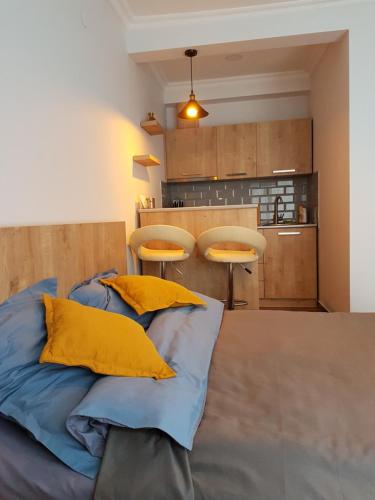 Cosy Apartment في بورجومي: غرفة عليها سرير ومخدات صفراء