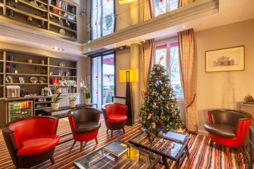 un soggiorno con un albero di Natale e sedie rosse di Hôtel Pavillon Bastille a Parigi