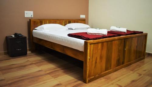 a large wooden bed with two towels on it at Viraz Valley in Gokarna