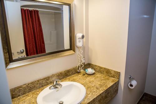 a bathroom with a sink and a phone on a counter at The Village Inn of Lakefield in Lakefield