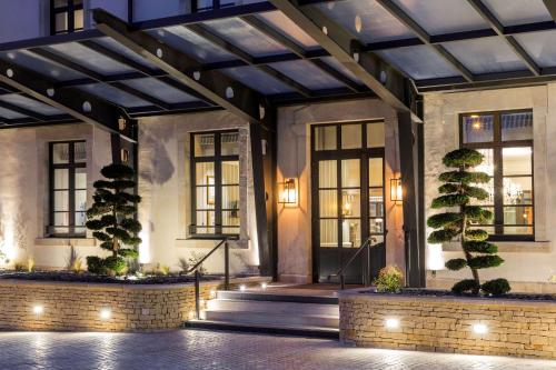 トゥールニュにあるHôtel & Spa Les Sept Fontaines Best Western Premierの木灯のある建物のロビー