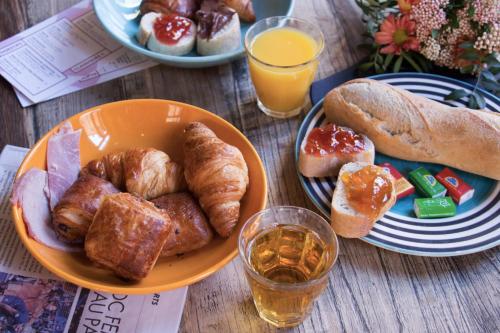 un plato naranja de bollería y pan en una mesa de madera en HO36 Hostel, en Lyon